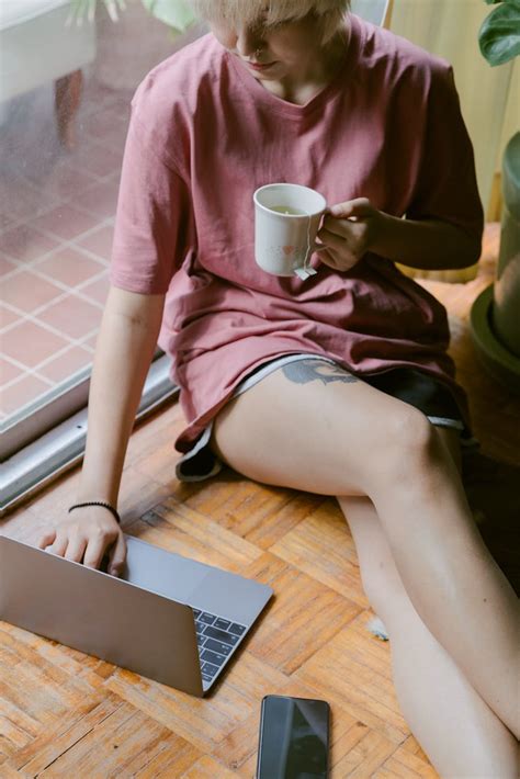 Focused woman browsing laptop while sitting on floor · Free Stock Photo