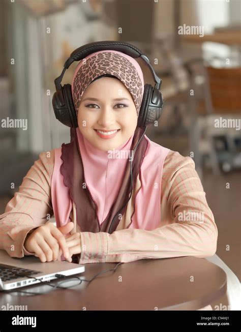 Muslim young girl wearing headphone on the coffee table Stock Photo - Alamy