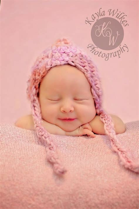 a newborn baby wearing a pink knitted hat