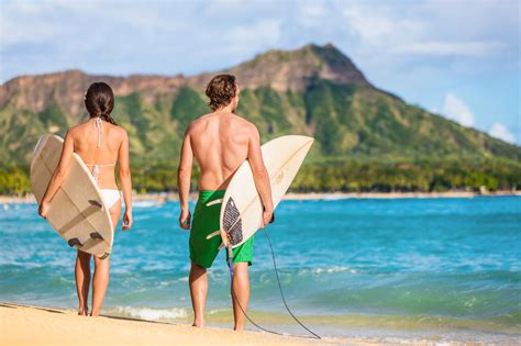 Hawaii surfers people relaxing on waikiki beach with surfboards looking at waves in Honolulu ...