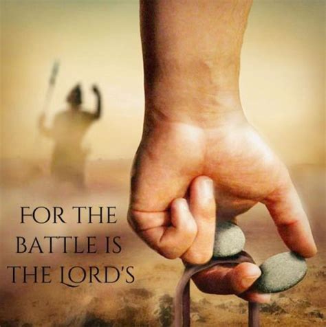 a hand holding a stone with the words for the battle is the lord's