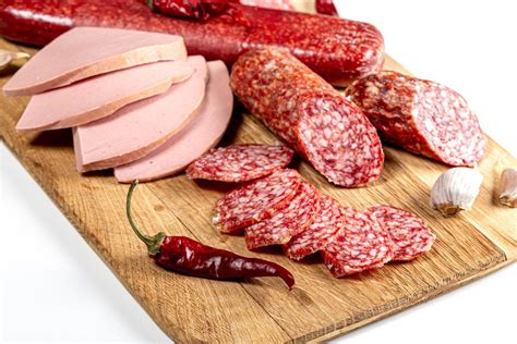 Smoked cured meats on wooden round kitchen board with fork - Creative Commons Bilder