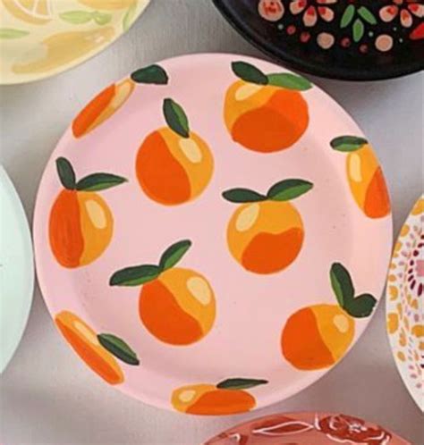 several plates with oranges painted on them