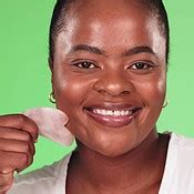 Face, cotton pad and black woman with makeup, beauty and grooming against a studio background ...