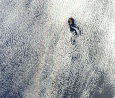 An optical phenomenon known as a “glory” is seen over a cloud-covered Pacific Ocean : r/space