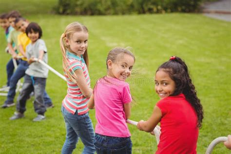 Cute Pupils Playing Tug of War on the Grass Outside Stock Photo - Image of male, people: 58139278