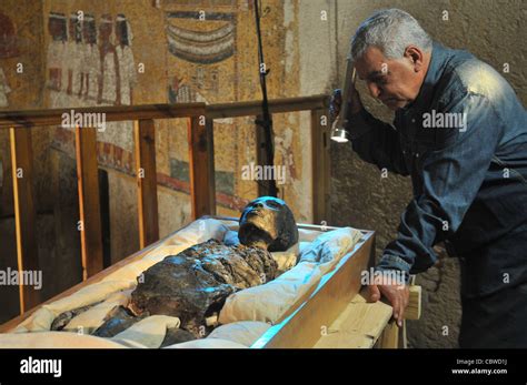 Zahi Hawass examining King Tut mummy inside the tomb of King Tut in the Valley of the Kings in ...