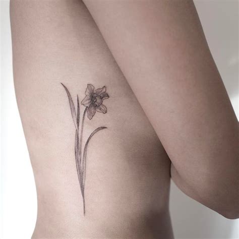 Delicate black daffodil tattoo along the rib cage. #daffodil #flowertattoo | Daffodil tattoo ...