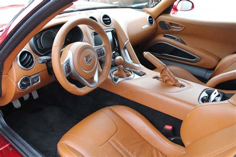 the interior of a sports car with tan leather and black stitching on ...