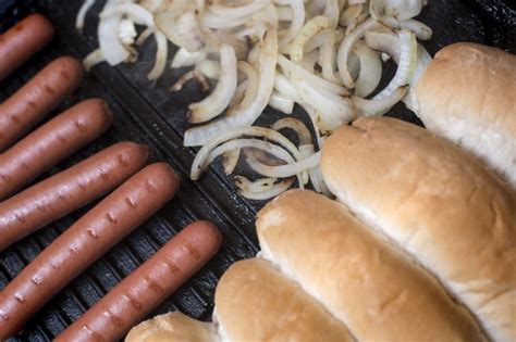 Cooking hot dog ingredients on a griddle - Free Stock Image