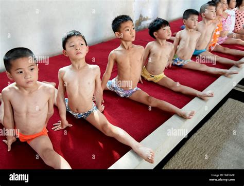 Chinese children do the splits to practice gymnastics at a gymnastics training center in Bozhou ...