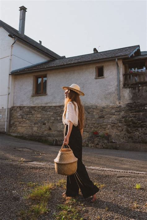 Woman Wearing Straw Hat on Village Street · Free Stock Photo