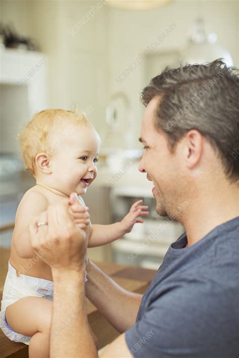 Father and baby laughing in kitchen - Stock Image - F014/3310 - Science Photo Library