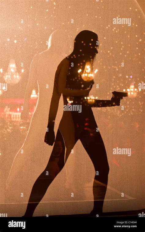 Shadow of a woman holding a gun at a James Bond theme party Stock Photo - Alamy