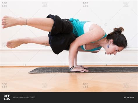 Woman in an advanced horizontal handstand yoga pose stock photo - OFFSET