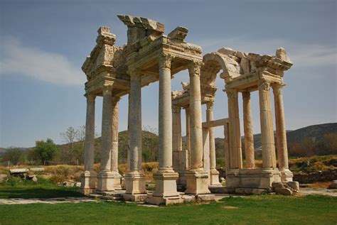 the ruins of an ancient roman city are covered in white marble and green grass, with mountains ...