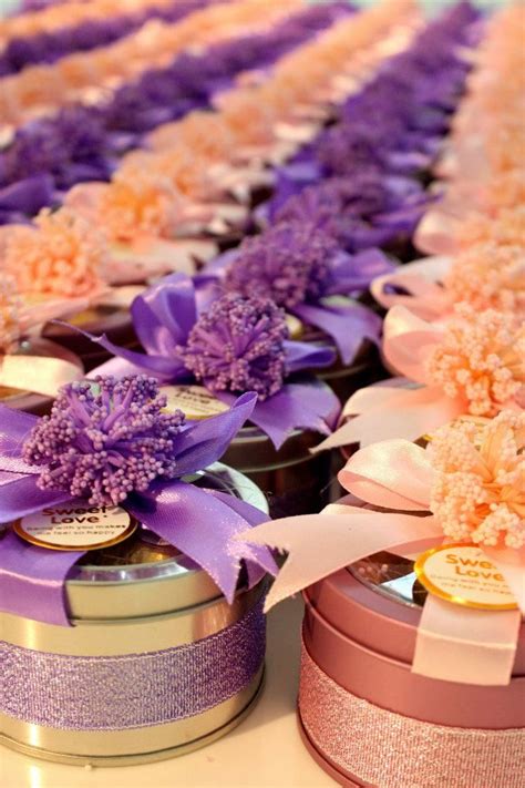 purple and white flowers are in small tins