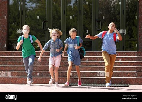 Cute kids running out of school Stock Photo - Alamy