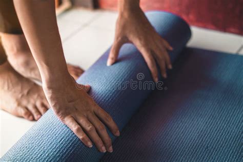 Young Asian Woman Rolling Blue Yoga Mat or Fitness Mat in Livingroom ...