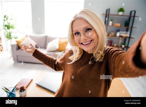 Selfie photo of good mood grandmother happy showing her new studio apartment looks like home ...