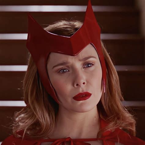 a woman wearing a red costume with horns on it's head and eyes closed