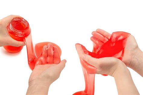 Premium Photo | Red slime toy in woman hand isolated on white