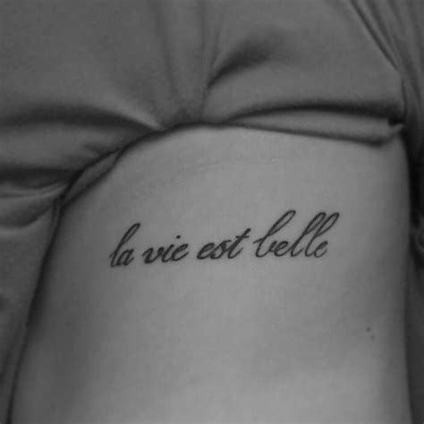 Side tattoo saying "La vie est belle" on Lisa.