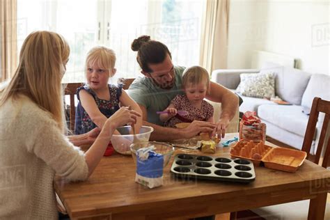 Family at home baking cakes together - Stock Photo - Dissolve