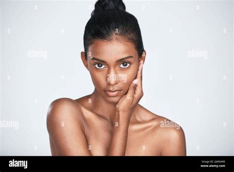 Less makeup, more of that natural glow. a beautiful young woman posing against a white ...