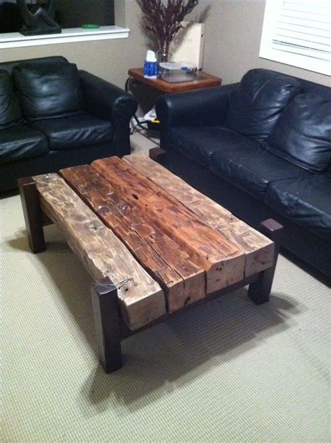 a living room with two black leather couches and a wooden table in the middle