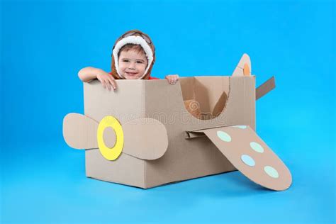 Cute Little Child Playing with Cardboard Airplane on Blue Background ...