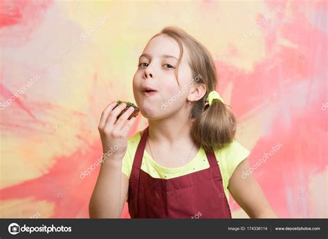 Girl eating cupcake — Stock Photo © stetsik #174336114