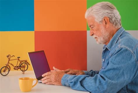 Premium Photo | Serious and worried old caucasian senior man using laptop on white desk colorful ...