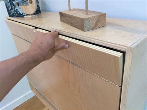 a hand is reaching into a wooden dresser