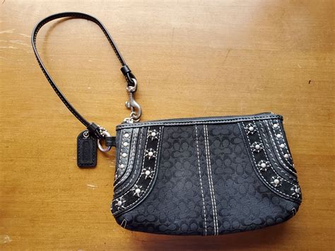 Black coach wristlet has really unique detail on the sides and the C pattern all over the rest ...