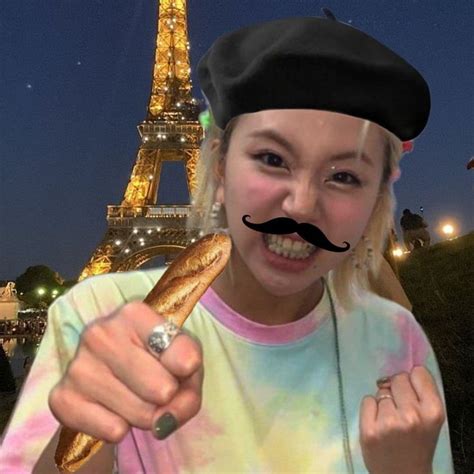 a woman with a fake moustache holding a hot dog in front of the eiffel tower