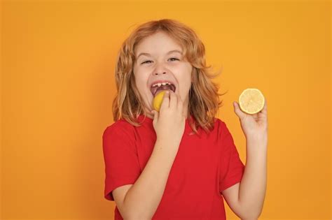 Premium Photo | Child eat lemon in studio studio portrait of cute kid boy lick lemon isolated on ...