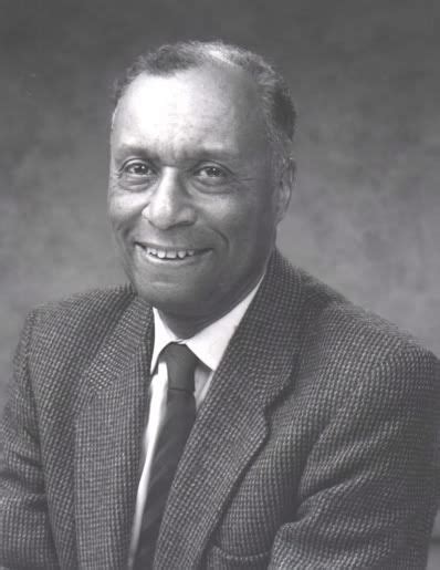 an old photo of a man in a suit and tie smiling at the camera with his arms crossed