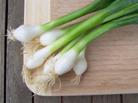 Download Spring Onions On Wooden Chopping Board Wallpaper | Wallpapers.com