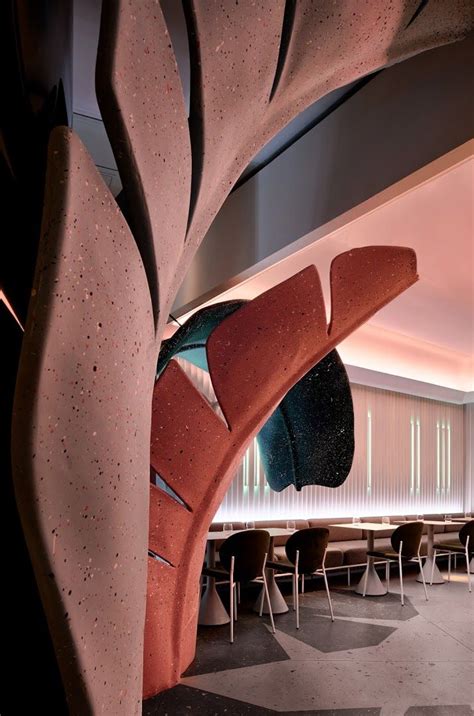 the interior of a restaurant with tables, chairs and a large sculpture on the wall