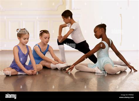 Group of young ballet dancers doing stretching exercises Stock Photo - Alamy