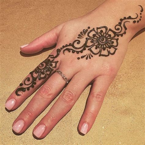 a woman's hand with a henna tattoo on it