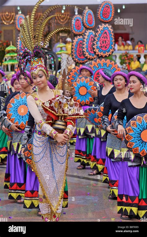 woman with sinulog costume and a Santo Niño doll in the sinulog parade Stock Photo - Alamy