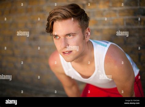 Runner stretching by brick wall Stock Photo - Alamy