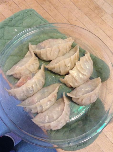 some dumplings are in a glass bowl on a table