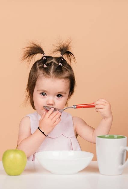 Premium Photo | Kid eat healthy nutrition baby food Babies eating with spoon Kid girl eating ...
