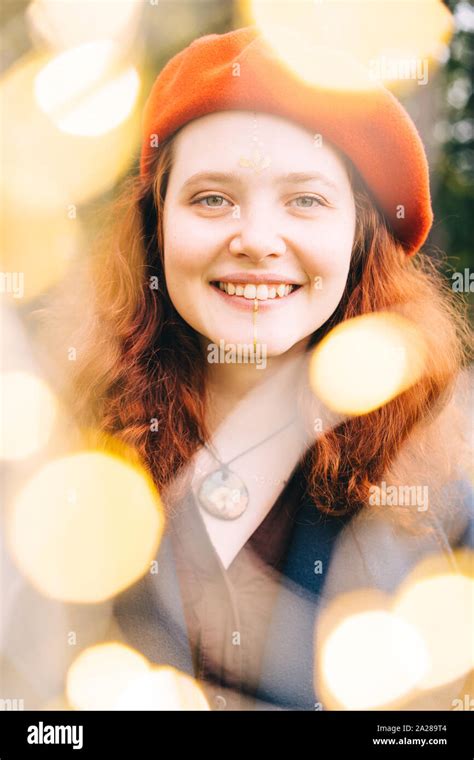 Beautiful young woman looks through the festive Christmas lights Stock Photo - Alamy