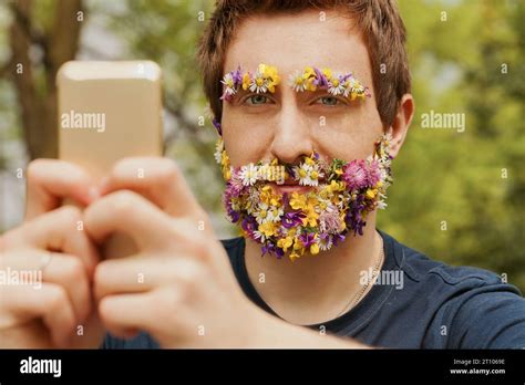 This individual, sporting spring flowers for facial hair, rests in the outdoors. He appreciates ...