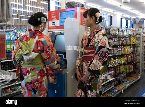 Japanese girls withdrawing money at ATM in convenience store, young ...