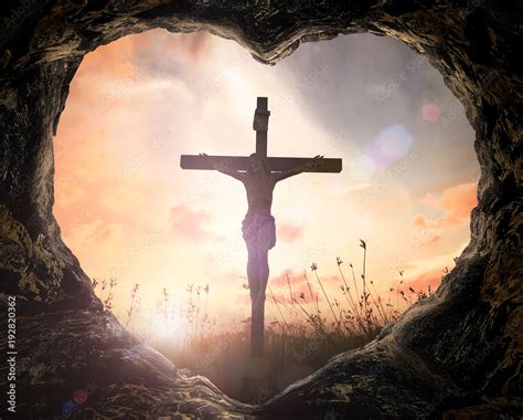 Photo Good Friday concept: Heart shape of cave with Jesus Christ on cross over meadow sunset ...